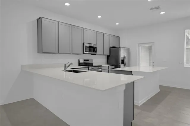 a kitchen with kitchen island a sink stainless steel appliances and cabinets