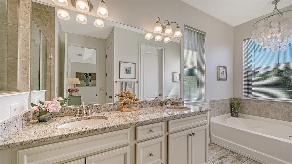 11211 Spring Gate Trail Lakewood Ranch, FL 34211 - Photo 27 of 51 a bathroom with a granite countertop sink a large mirror and a bathtub