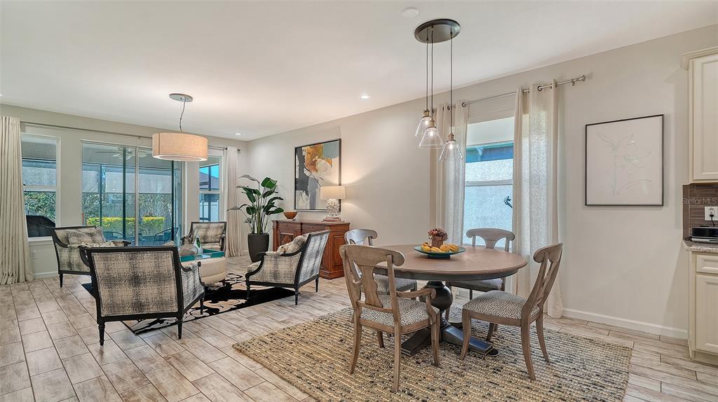 11211 Spring Gate Trail Lakewood Ranch, FL 34211 - Photo 10 of 51 a dining room with furniture a chandelier and wooden floor