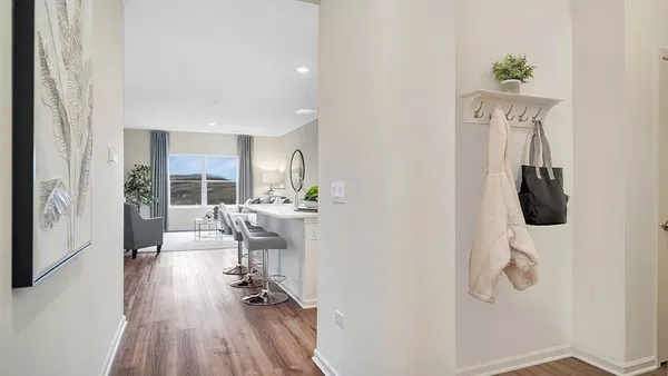 a view of a hallway with wooden floor and dining room view