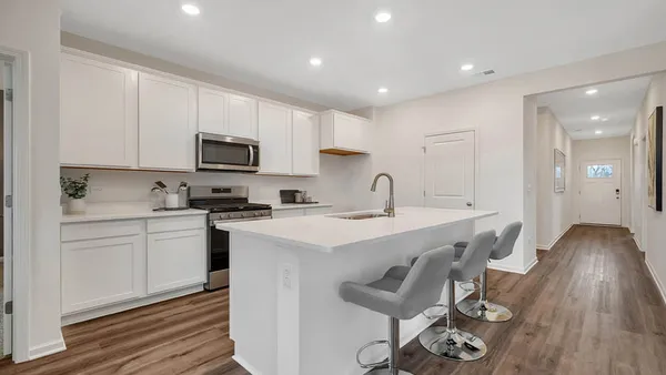 a kitchen with a sink cabinets and wooden floor
