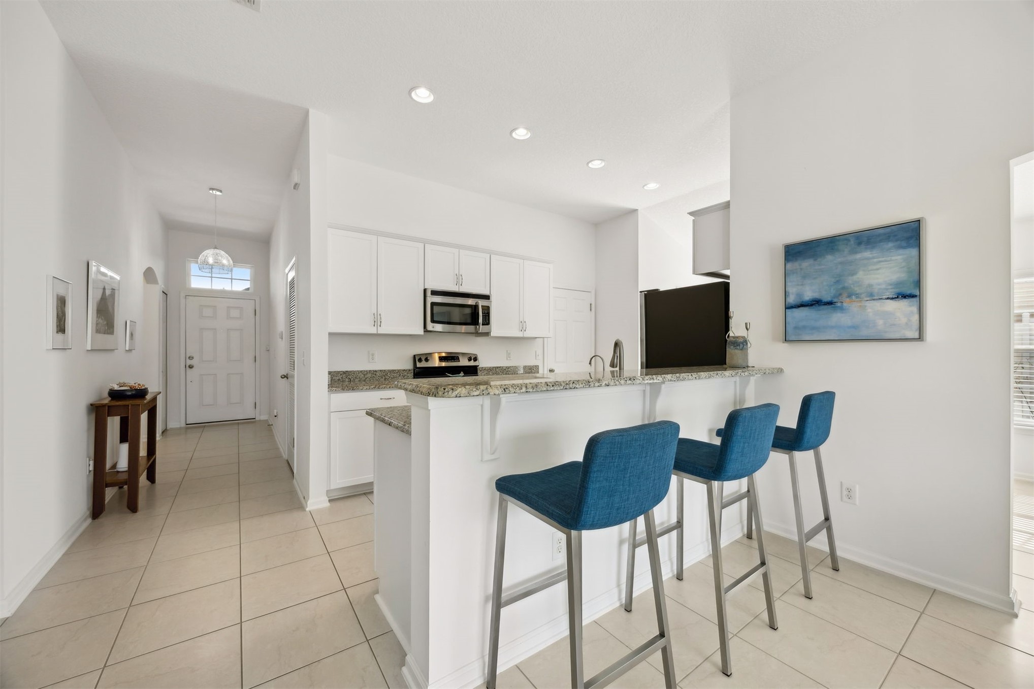 94037 Last Lane Yulee, FL 32097 - Photo 11 of 38 a kitchen with stainless steel appliances kitchen island granite countertop a refrigerator and microwave