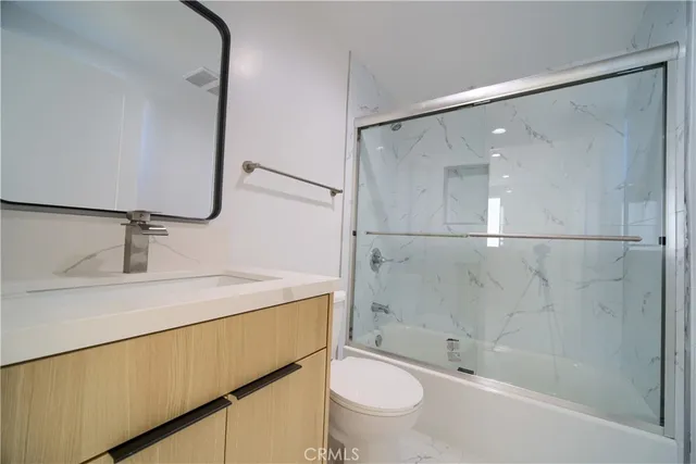 a bathroom with a sink mirror toilet and bathtub