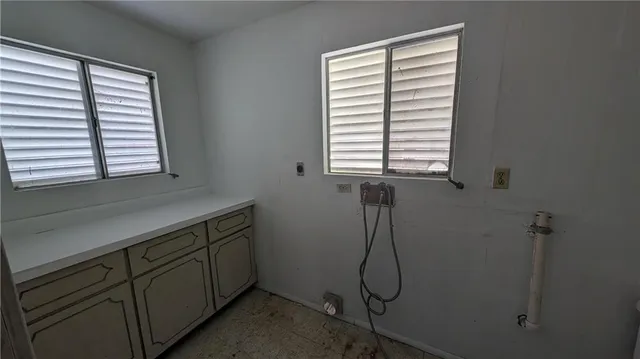 a bathroom with a window sink and cabinets