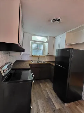 a kitchen with a sink a stove a refrigerator and cabinets