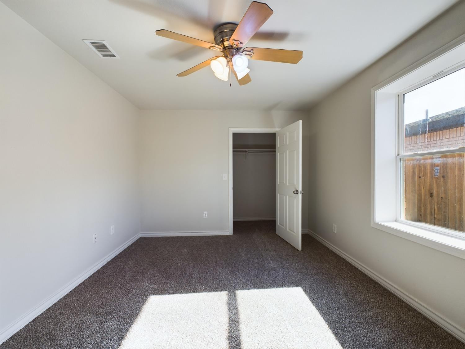 6306 25th Street Lubbock, TX 79407 - Photo 14 of 37 an empty room with windows and fan