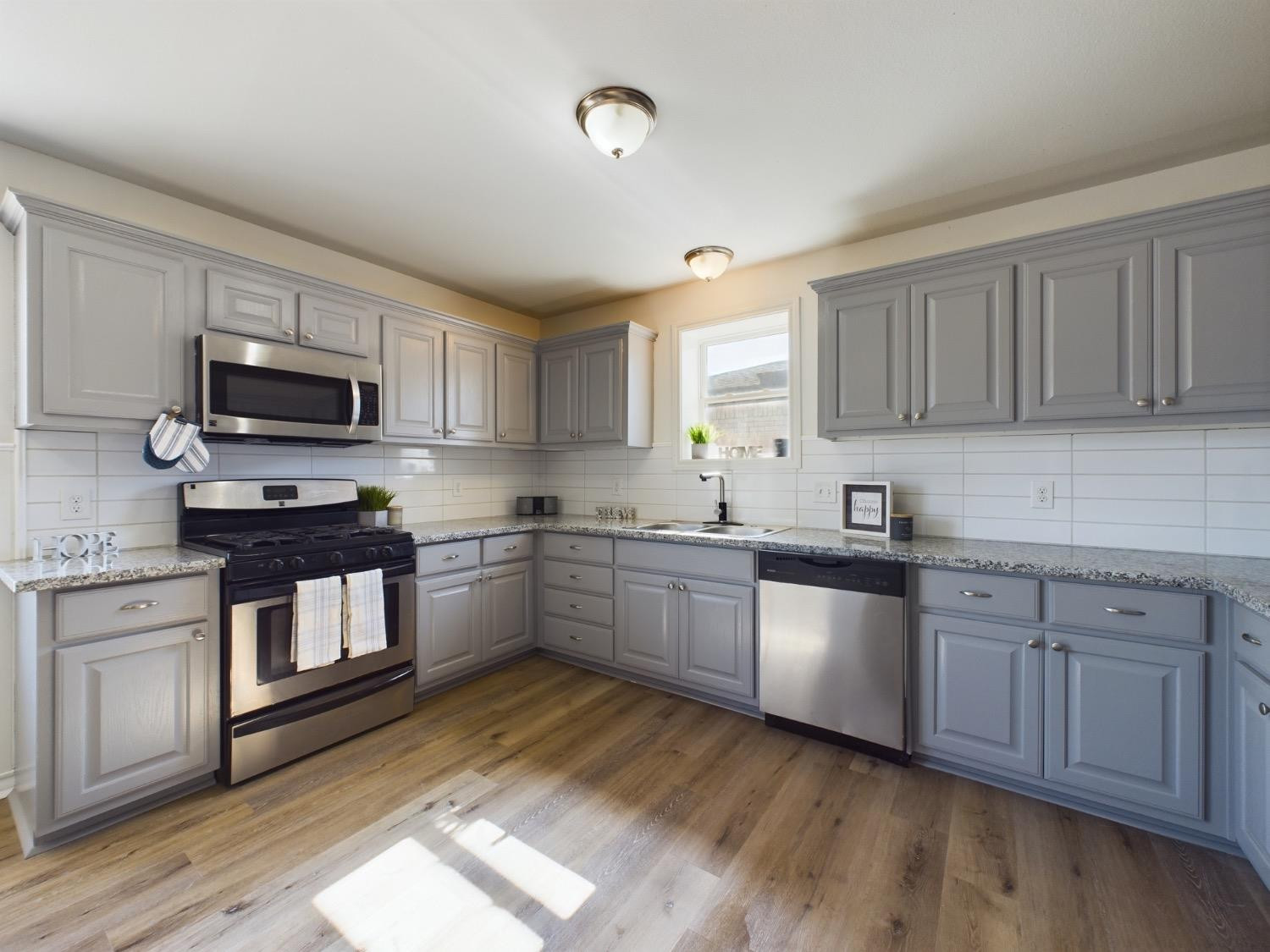 6306 25th Street Lubbock, TX 79407 - Photo 26 of 37 a kitchen with stainless steel appliances granite countertop a stove sink microwave and cabinets