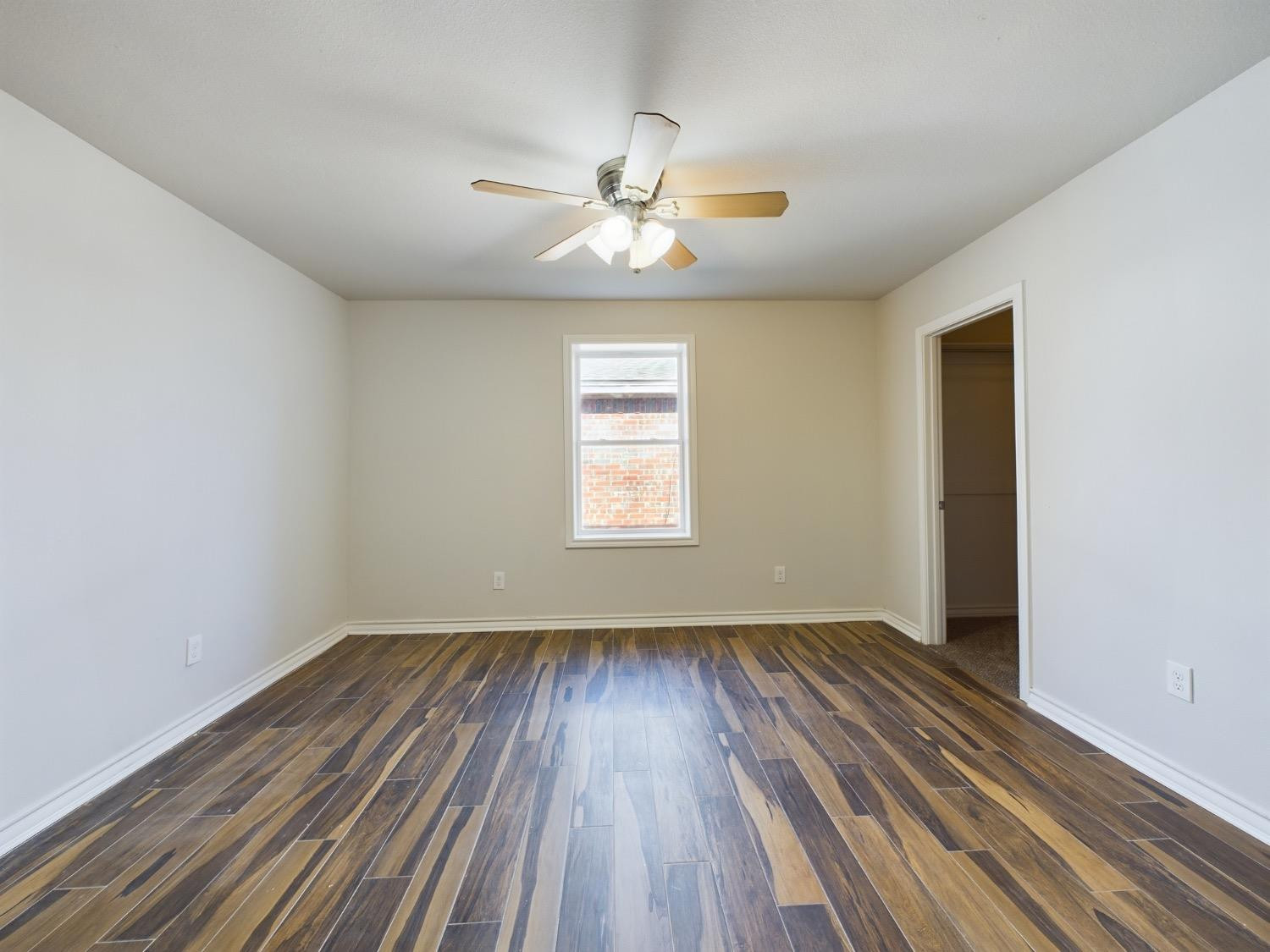 6306 25th Street Lubbock, TX 79407 - Photo 31 of 37 wooden floor in an empty room with a window