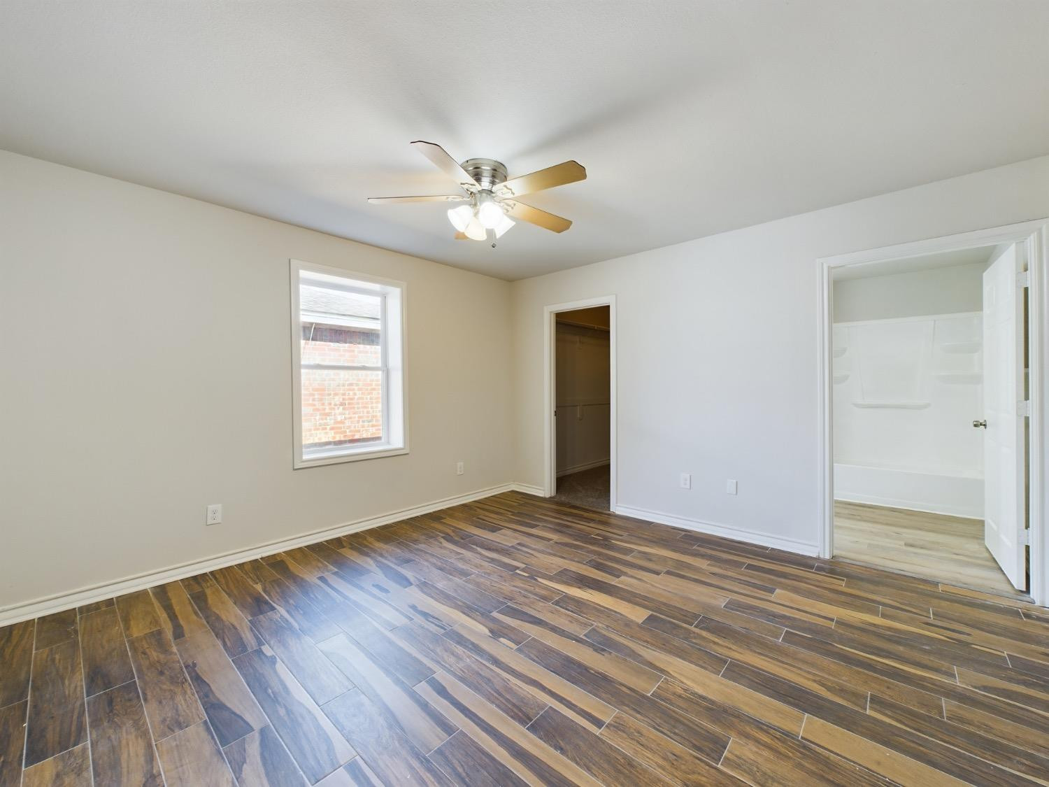 6306 25th Street Lubbock, TX 79407 - Photo 32 of 37 a view of an empty room with wooden floor and a window