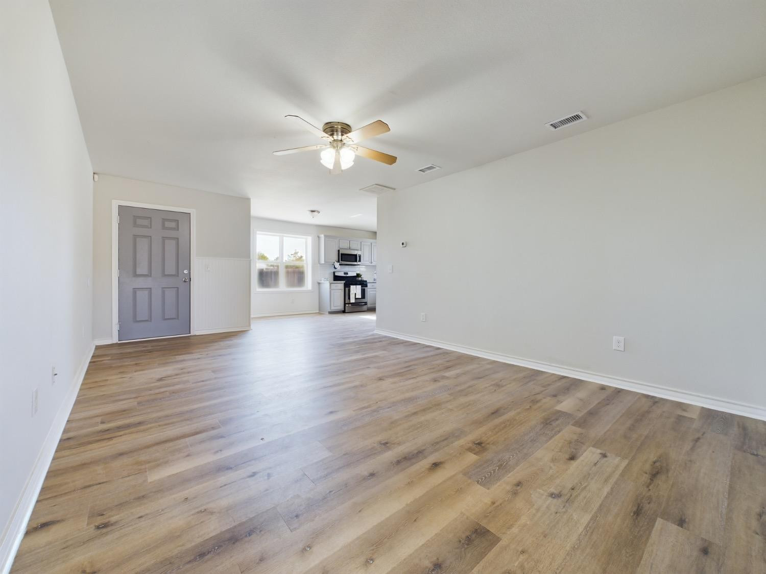 6306 25th Street Lubbock, TX 79407 - Photo 5 of 37 wooden floor in an empty room with a window