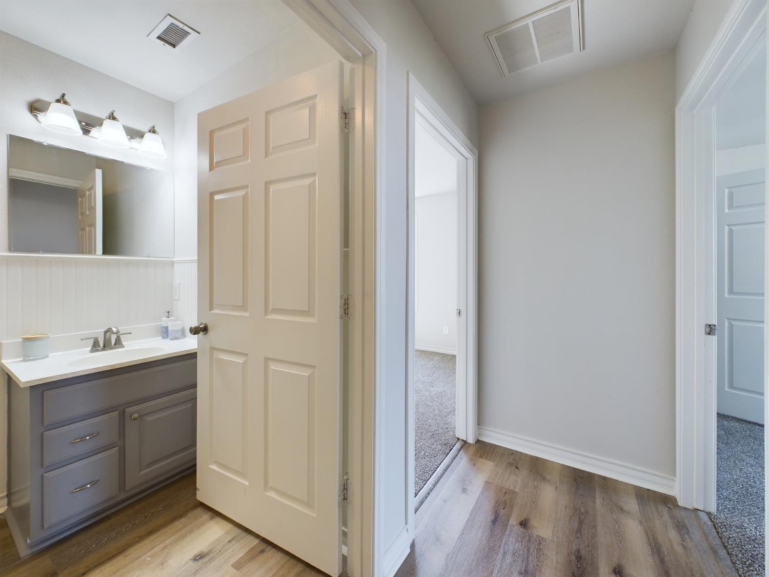 6306 25th Street Lubbock, TX 79407 - Photo 9 of 37 a view of a bathroom with sink mirror and wooden floor
