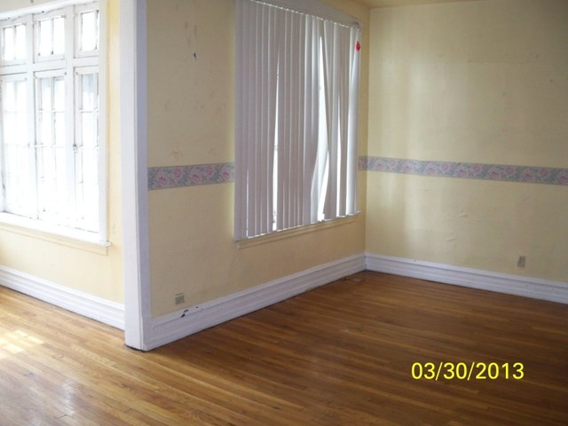 5010 North Troy Street Chicago, IL 60625 - Photo 4 of 19 a view of an empty room with wooden floor and a window