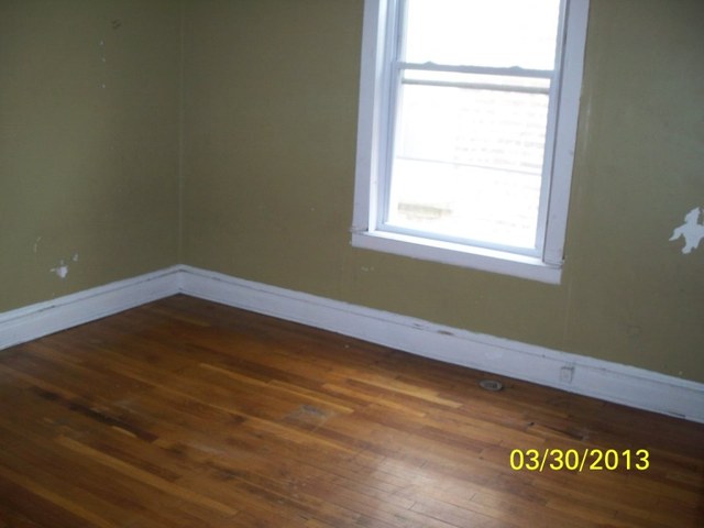 5010 North Troy Street Chicago, IL 60625 - Photo 6 of 19 a view of an empty room with wooden floor and a window