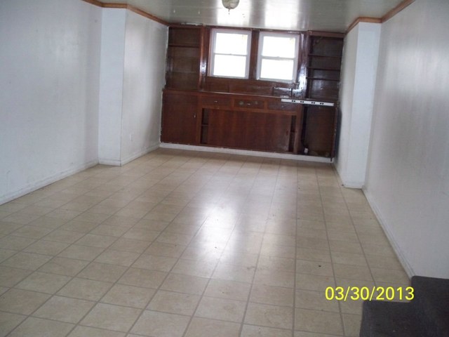 5010 North Troy Street Chicago, IL 60625 - Photo 9 of 19 an empty room with a kitchen and a sink