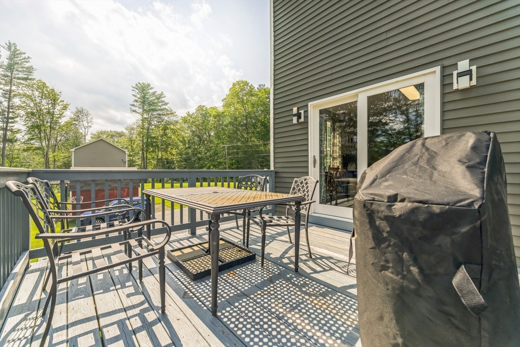 121 Adams Road East Brookfield, MA 01515 - Photo 11 of 28 a view of a patio with table and chairs with wooden floor and fence