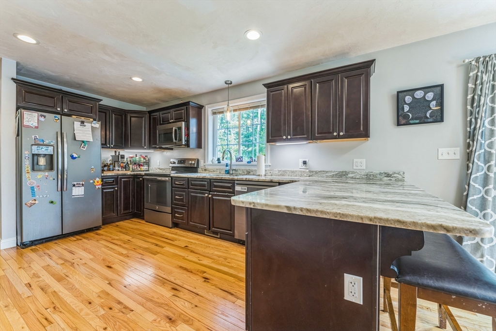 121 Adams Road East Brookfield, MA 01515 - Photo 4 of 28 a kitchen with stainless steel appliances granite countertop a refrigerator a sink dishwasher a stove with wooden cabinets and floor