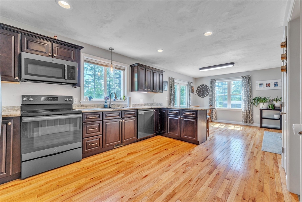 121 Adams Road East Brookfield, MA 01515 - Photo 5 of 28 a kitchen with stainless steel appliances wooden floors and wooden cabinets