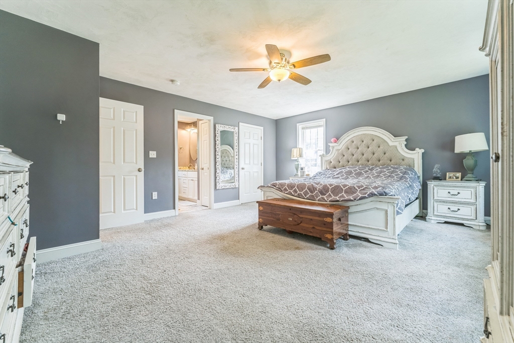 121 Adams Road East Brookfield, MA 01515 - Photo 10 of 28 a spacious bedroom with a bed and a chandelier