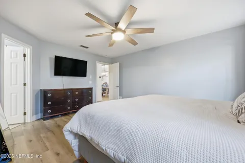 a bedroom with a bed and a flat screen tv