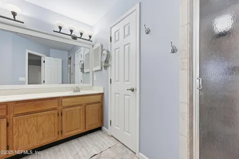 a spacious bathroom with a double vanity sink a mirror and a bathtub