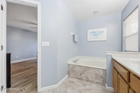 a bathroom with a tub sink and vanity