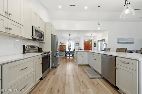 a kitchen with stainless steel appliances granite countertop lots of counter top space and wooden floors