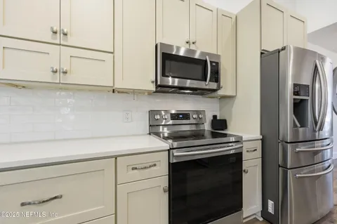 a kitchen with stainless steel appliances white cabinets and a stove top oven
