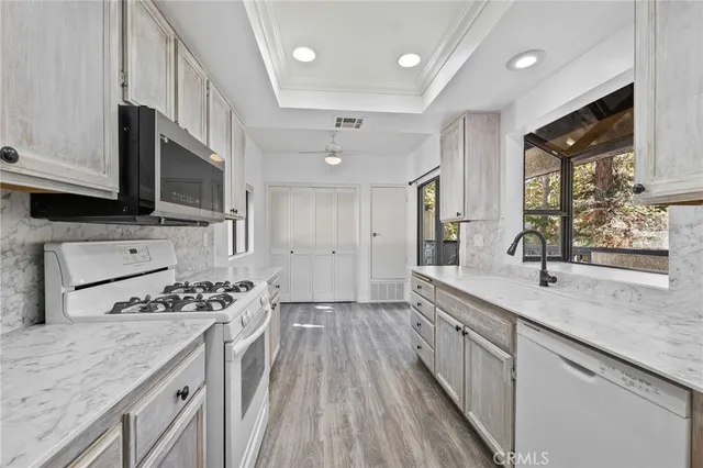 a view of a kitchen with a sink and dishwasher a refrigerator with wooden floor