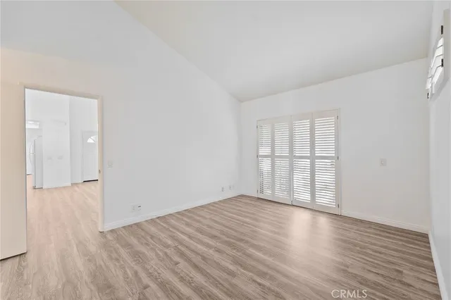 a view of a big room with wooden floor and a window