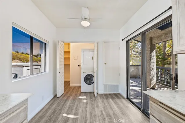 a view of an empty room with wooden floor fireplace and a window