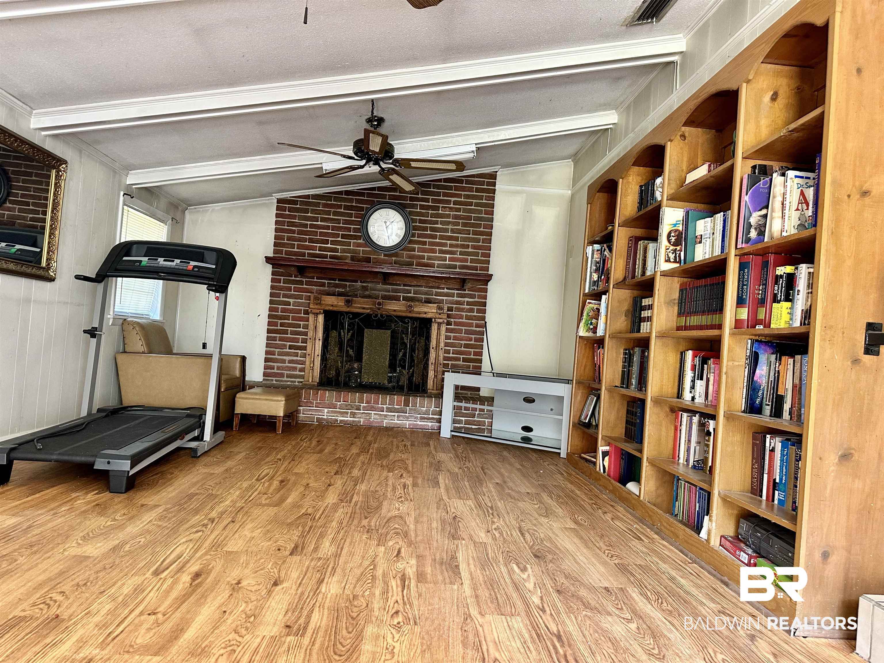 2593 Foshee Road Brewton, AL 36426 - Photo 5 of 15 Exercise room featuring a textured ceiling, a brick fireplace, ceiling fan, lofted ceiling, and light hardwood / wood-style flooring