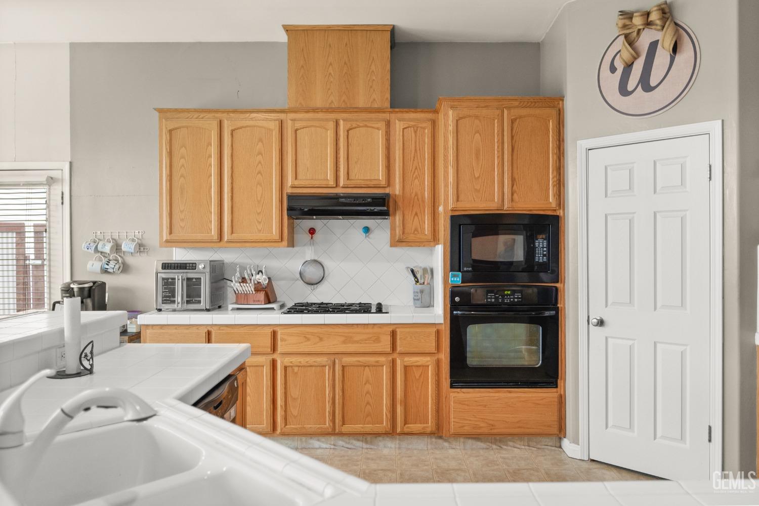 Undisclosed Address Bakersfield, CA 93306 - Photo 14 of 42 a kitchen with a sink cabinets and a stove