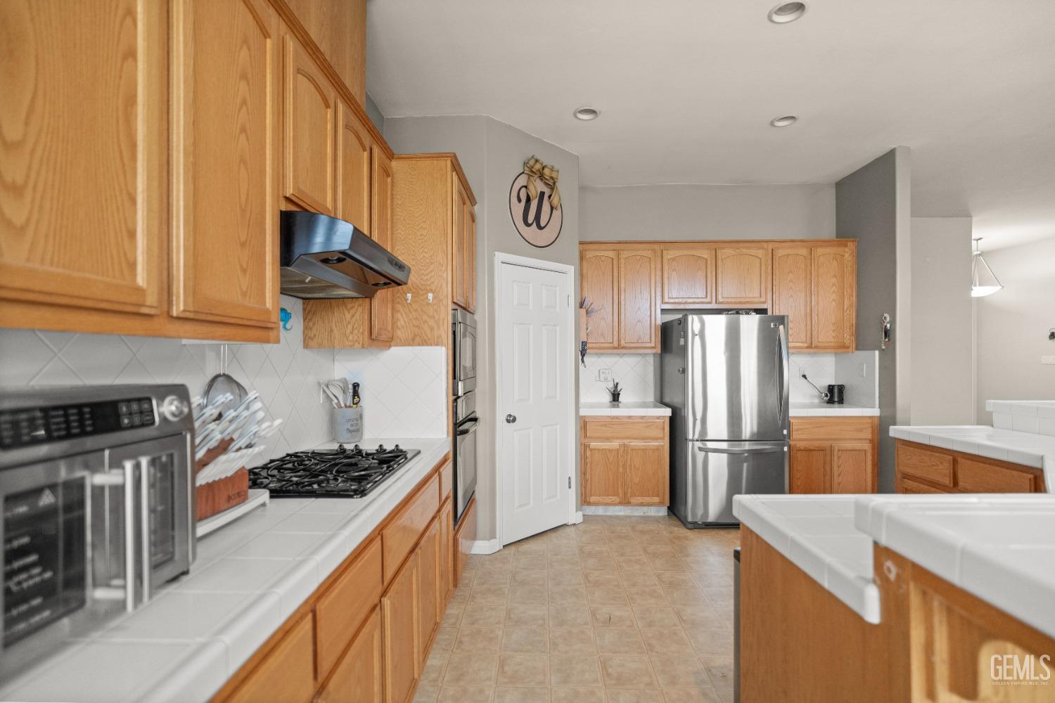 Undisclosed Address Bakersfield, CA 93306 - Photo 17 of 42 a kitchen with a refrigerator and a stove top oven