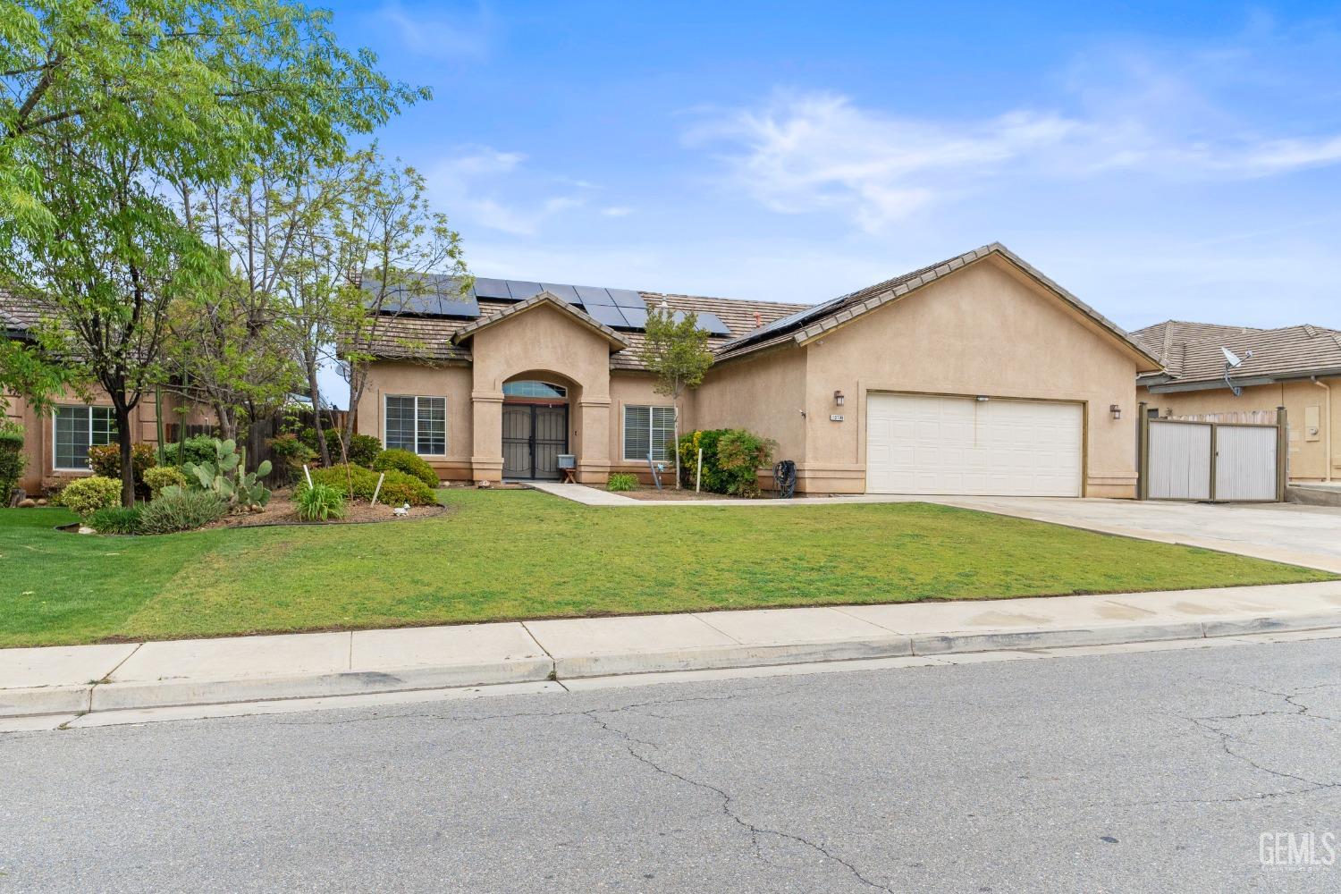Undisclosed Address Bakersfield, CA 93306 - Photo 3 of 42 a front view of a house with a garden and trees