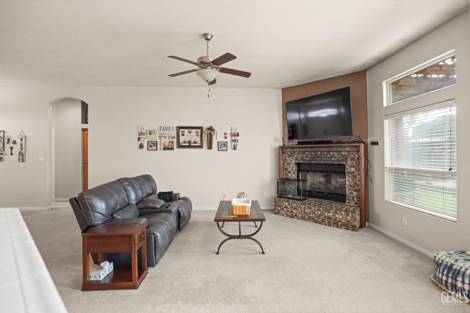 Undisclosed Address Bakersfield, CA 93306 - Photo 9 of 42 a living room with furniture a flat screen tv and a fireplace