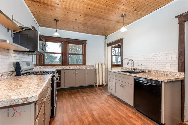 a kitchen with a stove top oven sink and a window