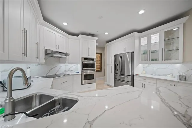 a kitchen with granite countertop a sink stainless steel appliances and cabinets