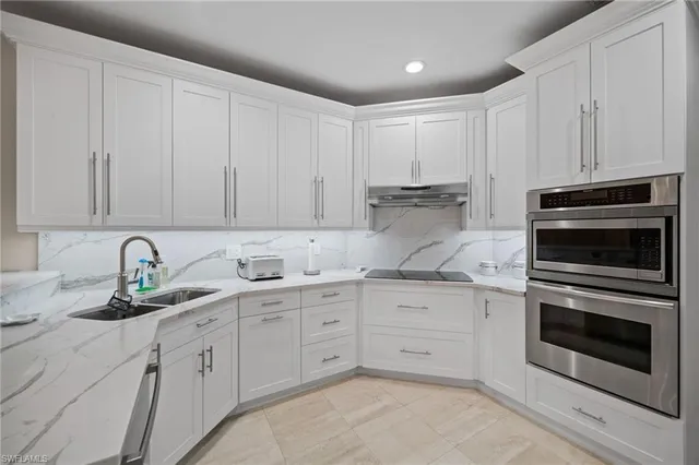 a kitchen with granite countertop white cabinets stainless steel appliances and sink