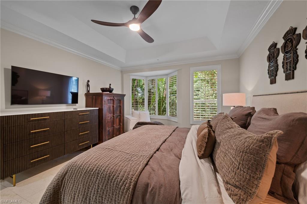 261 Colonade Circle, Unit 2701 Naples, FL 34103 - Photo 18 of 49 a bedroom with a bed and a flat screen tv