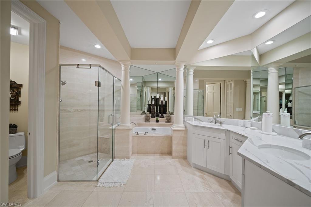 261 Colonade Circle, Unit 2701 Naples, FL 34103 - Photo 20 of 49 a large bathroom with a glass door shower sink and mirror
