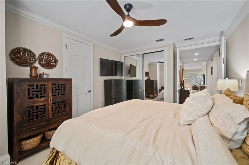 261 Colonade Circle, Unit 2701 Naples, FL 34103 - Photo 27 of 49 a bedroom with a bed and a chandelier