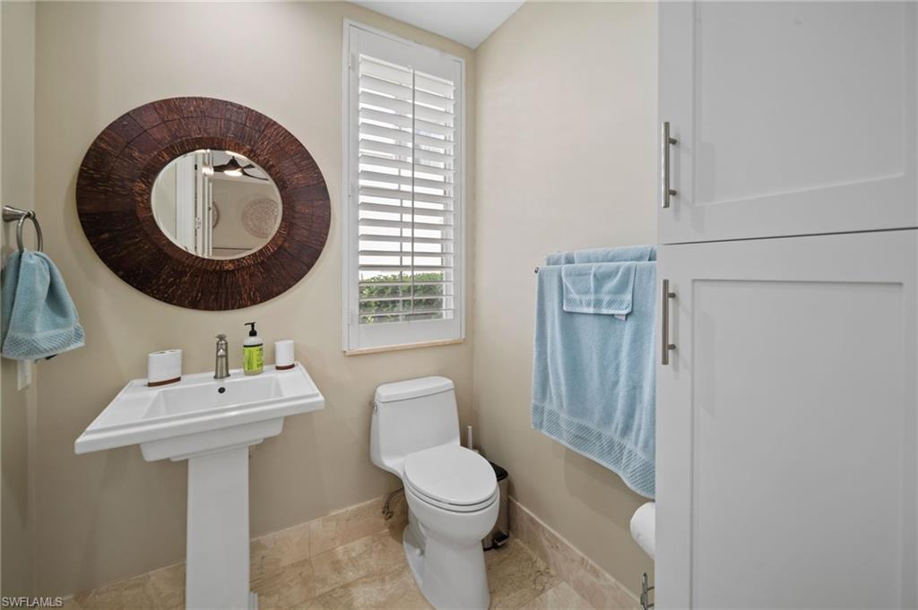 261 Colonade Circle, Unit 2701 Naples, FL 34103 - Photo 29 of 49 a bathroom with a toilet a sink and a mirror