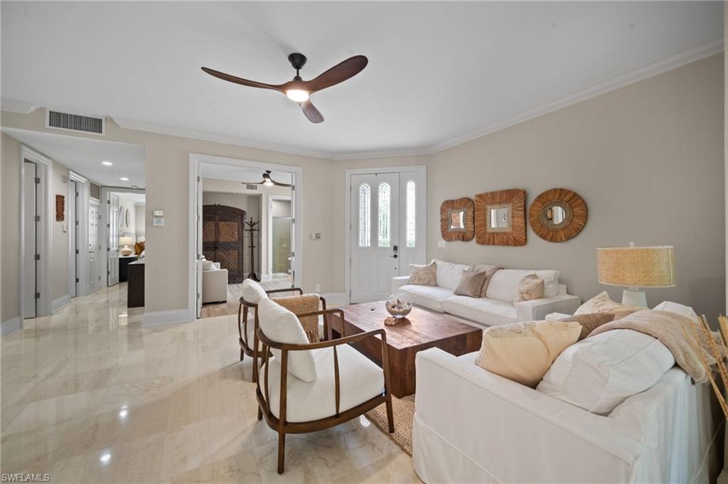 261 Colonade Circle, Unit 2701 Naples, FL 34103 - Photo 5 of 49 a living room with furniture and a clock