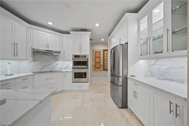 a kitchen with granite countertop a refrigerator stove and cabinets