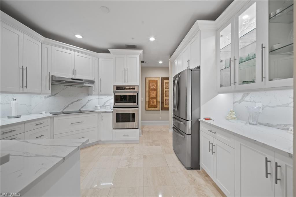 261 Colonade Circle, Unit 2701 Naples, FL 34103 - Photo 10 of 49 a kitchen with granite countertop a refrigerator stove and cabinets