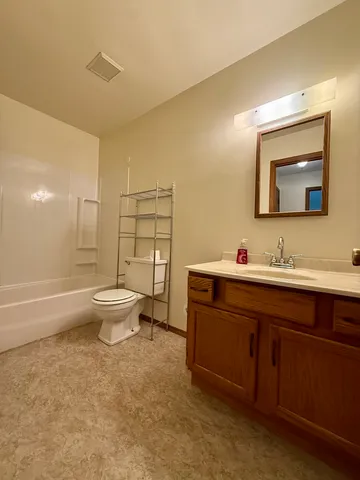 a bathroom with a toilet sink double vanity and mirror