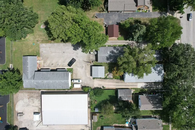 an aerial view of residential houses with outdoor space and trees