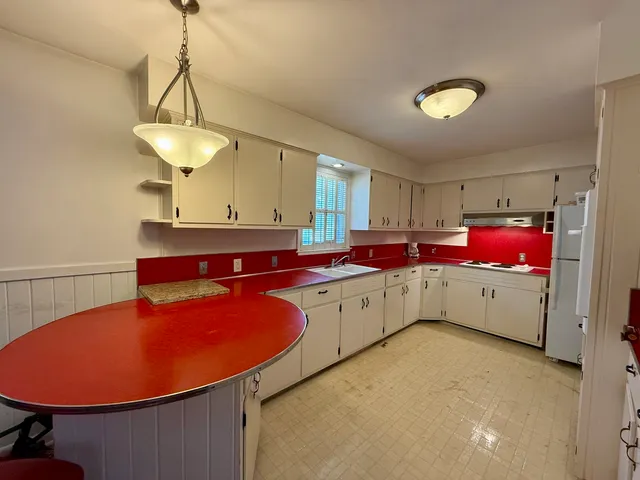 a kitchen with granite countertop a sink cabinets and window