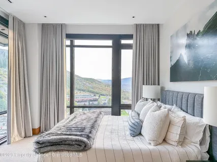 a bedroom with a bed and a large window