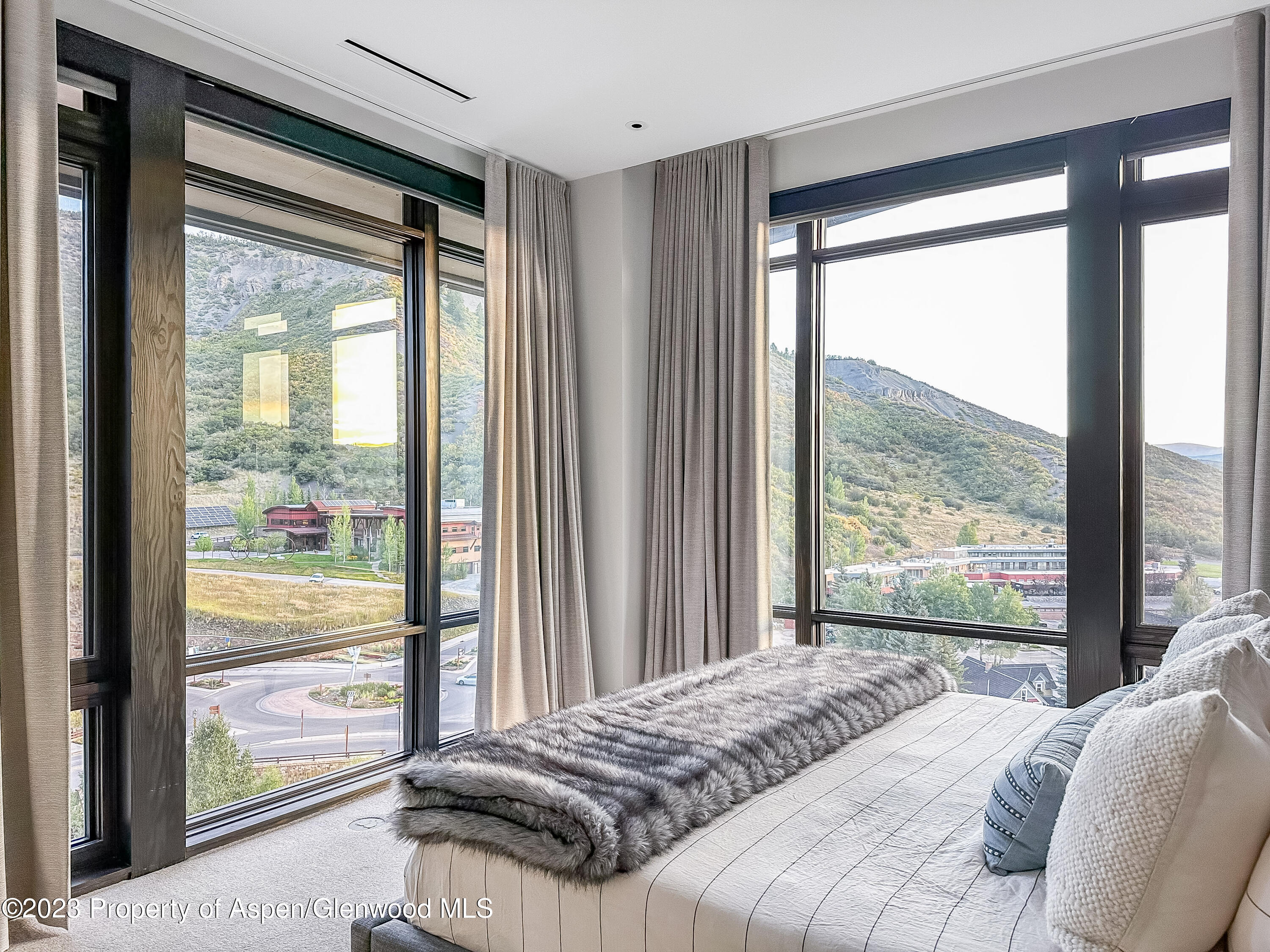 77 Wood Road, Unit 607E Snowmass Village, CO 81615 - Photo 12 of 29 a bedroom with a bed and glass window